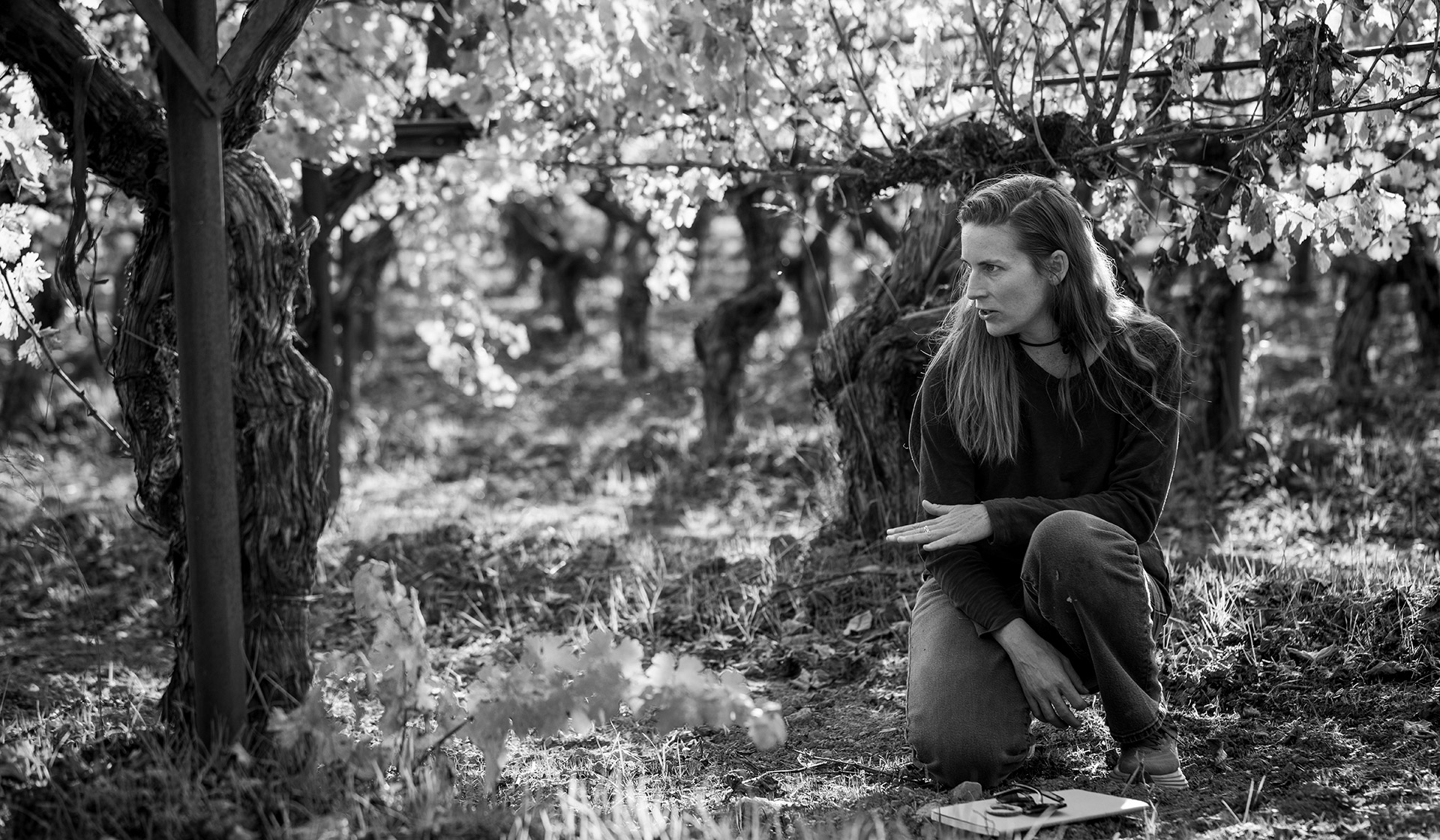 Chiara crouched in the vineyard